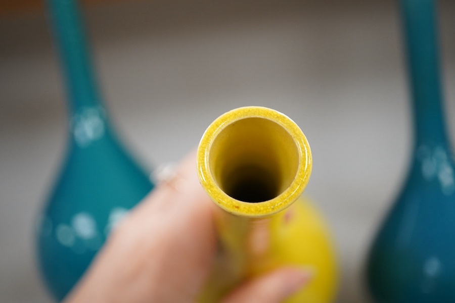 A late 19th century Japanese turquoise glazed narrow neck bottle vase, 31cm high, a smaller similar vase, 22cm high and a tall yellow glazed vase, 31cm high. Condition - repair to neck of yellow vase